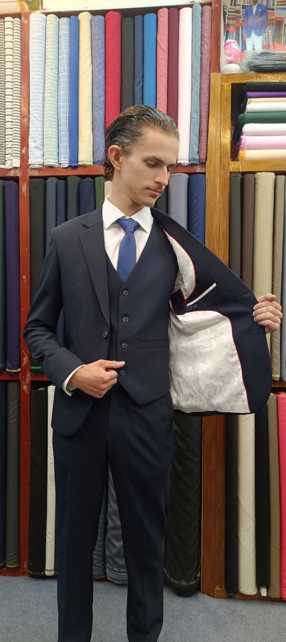 Customer showing the light patterned lining of a navy three-piece suit